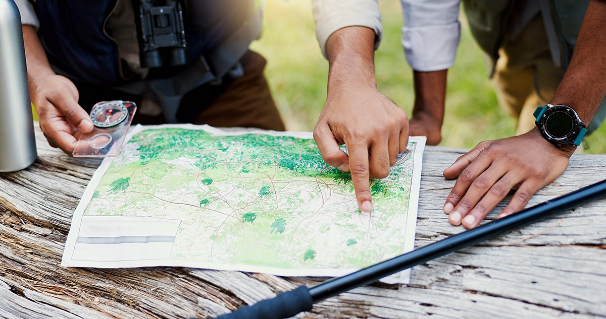 Hands, people and maps with compass for hiking of trekking direction, forest navigation and route. Lost friends, point and guide with woods location for travel journey, adventure path and destination.