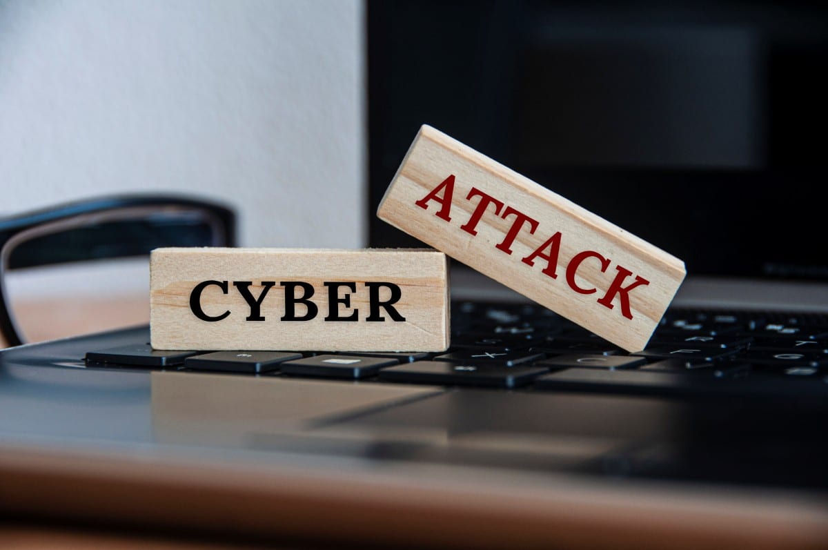Cyber attack text on wooden blocks on top of a laptop