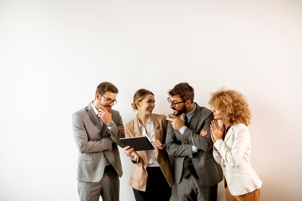 business people using digital tablet while standing by the wall in the office