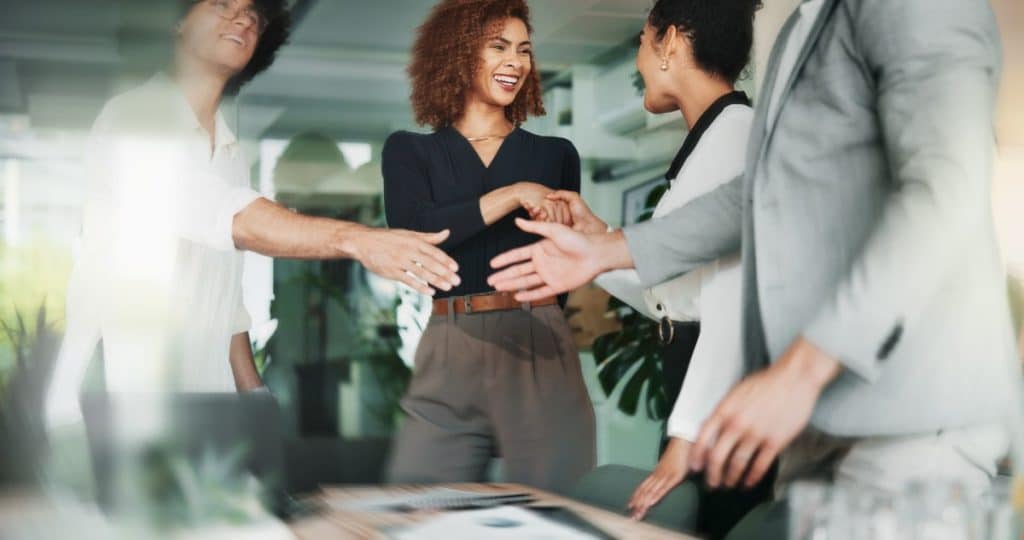 People, happy and handshake in office for business, creative collaboration and industry merger