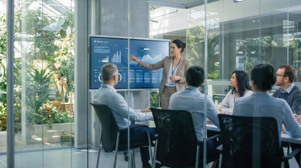 Workers discuss agribusiness technology in a modern conference setting with green surroundings