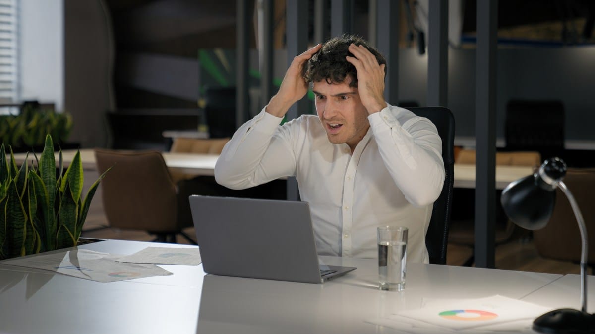 Shocked Caucasian businessman with laptop failure in office business man shock problem fail lose online trouble company crisis male professional computer