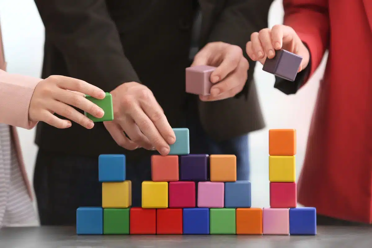 Group of people with colorful cubes, closeup Unity concept
